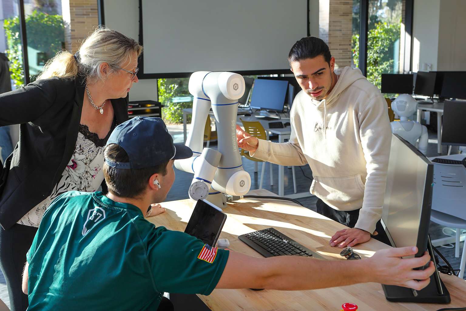 Researchers interacting with a collaborative robotic arm in a modern AI research lab environment